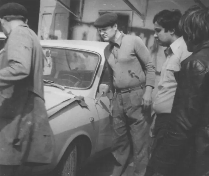Clienți și mecanici lângă un autoturism